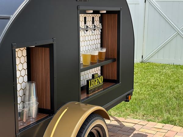 4-tap drink trailer styled for a birthday party with a sign at the taps