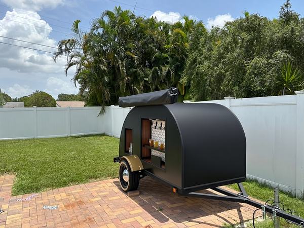 Front of the 4-tap party trailer set up in a backyard