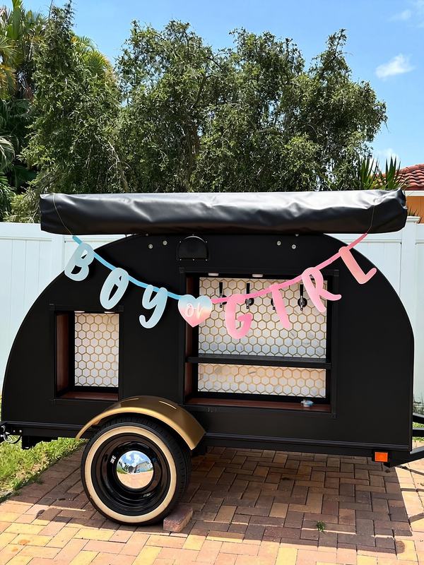 Party trailer styled for a gender reveal with a banner