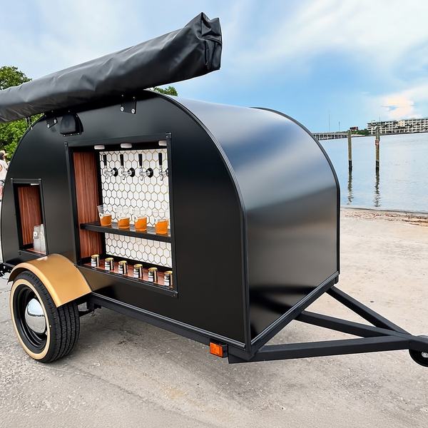 Black 4-tap tap trailer parked beside the water